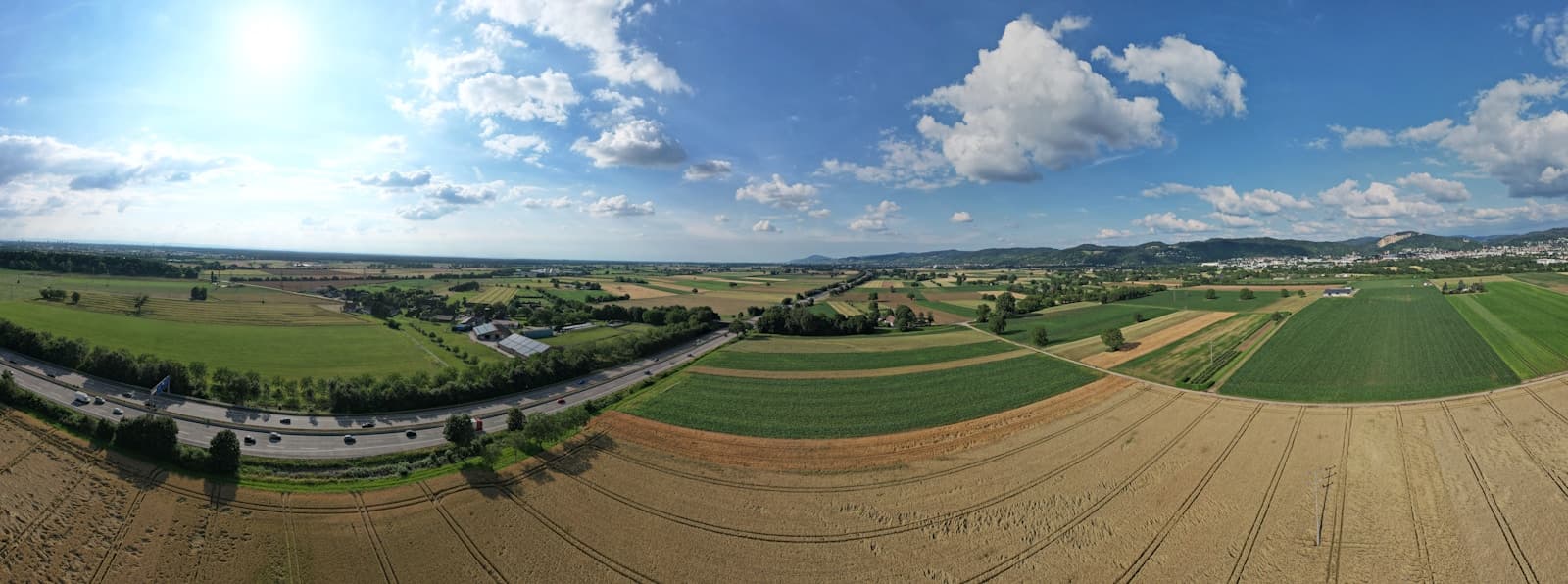 An aerial view of farmland divided into fields of different colours